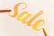 Orange painted lettering SALE on white background