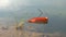 Orange paper boat floating on a lake