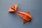 Orange paper fish origami isolated on a grey background