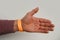 orange paper wristband mockup on persons arm. Clear adhesive bangle wristlet sticker with entry number on hand of middle-aged