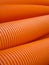 Orange perforated drainage pipe, corrugated.