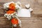 Orange persian buttercup flower and baby`s breath on wood