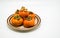 Orange persimmons on a small plate on white