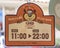 Orange plastic sign where the opening hours are recorded with a bear mascot and the message Thank you and see you again