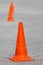 Orange plastic traffic cones on asphalt.