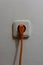 Orange plug connected to a white socket