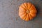 Orange pumpkin on grey background, top view. Space for text. Autumn vegetables. Halloween, Thanksgiving food preparations