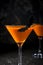 Orange pumpkin martini Halloween drink for party over black background. copy space