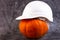 Orange pumpkin and white construction helmet, hard hat