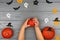 Orange pumpkins on a gray background. Baby hands on a gray background with orange pumpkins. Bats, white and black ghosts