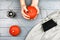 Orange pumpkins on a gray background. Female hands with autumn manicure on a gray background with orange pumpkins. View