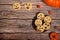 Orange pumpkins and physalis, cookies with scary smiles on a wooden background. Free space for your text.