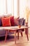 Orange, red and beige pillows on grey comfortable couch in chic living room interior