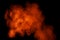 Orange red  powder explosion on black background.Orange red color dust splash clouds