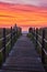 Orange and red sunrise light with straight boardwalk path guiding you to beach