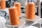 Orange reels of threads industry background, Spools of colored cotton thread, ordered composition