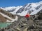 Orange reinforced tent against the background of a glacier on a high-altitude plateau. Extreme overnight stay in the mountains