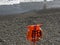 Orange rescue equipment hangs on the pebble beach of the foamy sea