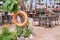 Orange rescue lifebuoy hangs on tree in front of beach restaurant at beach side, tropical