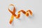 Orange ribbon on white background - Concept of leukemia awareness, kidney cancer association, multiple sclerosis and animal abuse