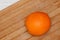 Orange ripe fruit on wooden board in kitchen.