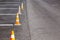 Orange road cones on a asphelt driving area with white lines