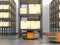 Orange robots carrying pallets with goods in modern warehouse