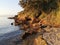 Orange rocky cliffs, sandy beach and Adriatic sea. Island Vir in Croatia late afternoon