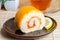 Orange roll cake in plate with orange slice