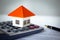 Orange roof house placed on a calculator or business information Business growth ideas, economic charts, real estate markets,