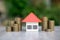 Orange roof model house In the middle of a pile of coins Real estate concept Home loan mortgage Future homes and home rentals