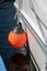 The orange round float is tied behind the boat to soften the blow to the dock when mooring