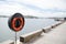 Orange round Life buoy at the waterfront.