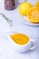 Orange sauce for duck poultry in a white gravy boat.