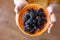 Orange saucer with frozen mulberries in children\'s hands