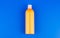 orange shampoo bottle on blue background, toiletries