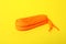 Orange shoe lace on yellow background. Stylish accessory