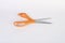 Orange and silver scissors on white back ground