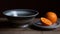 an orange sitting on a plate next to a bowl on a table