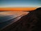 Orange sky at dusk over sandy beach in Apulia, with Sila mountains profile at the horizon, San Pietro in Bevagna