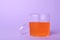 Orange slime in plastic container on background. Space for text