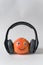 Orange smiley with headphones on white background. Fruit with eyes and smile. Food with Funny Faces