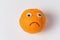 Orange smiley on white background. Orange with eyes and sad smile. Food with Funny Faces