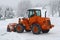 Orange snow plows to work clearing the snow