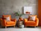 Orange snuggle chair and rustic side tables near stucco wall. Interior design of modern living room