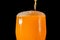 Orange soda large glass, overflowing glass of orange soda closeup with bubbles isolated on black