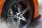 Orange Sport Car with detail on spinning and smoking wheels/tires doing burnouts