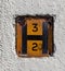 Orange square fire hydrant sign in a wall in the town centre of Widnes April 2019