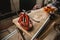 An orange steel pipe vise bolted onto a wooden makeshift table. A large ratchet is lying on the same table.