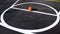 Orange striped basketball ball stands in circle on the marking playing field.